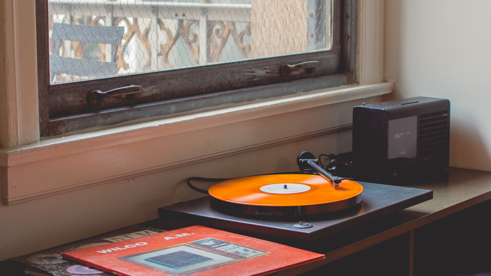 A laptop running music software next to studio monitors on a desk.
